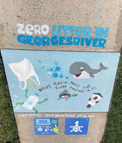 Finished artwork at Oatley memorial Park showing a grey and white whale and a frog, turtle and bird morphed as litter and words stating "Reduce plastic, make the river fantastic"