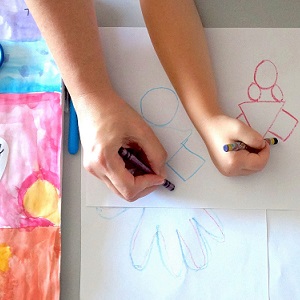 A kid and an adult hand drawing together