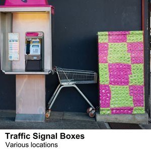 A colourful traffic signal box in a vinyl that looks like green and pink crocheted designs.