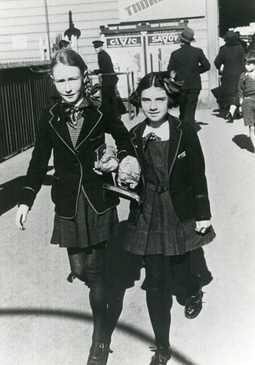 white and black picture of two girls walking on the street
