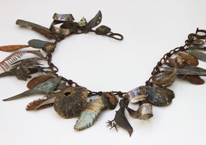 Bracelet made of found natural items showing shells and leaves.