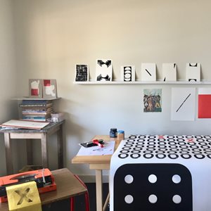 art studio with three wooden tables and paper work