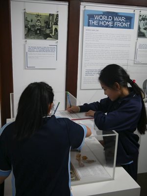 two young girls filling out a school trail in our exhibition