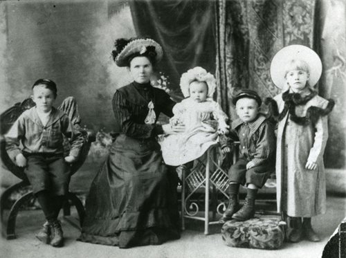 white and black picture of a lady with four children in the 19 hundrets
