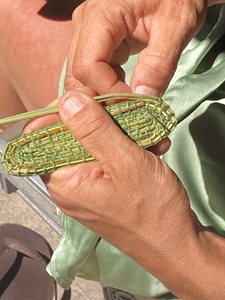 Hands weaving an oval shape