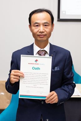 Image of Cr Ben Wang holding up Signed Councillor Affirmation