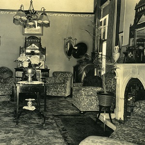 A sepia-coloured photograph of a living room of from the Villa Maria Estate in 1920.
