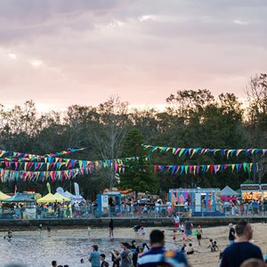 Australia day 2020 event showing stalls, crowds and flag banners across the water section of Carss Bush Park